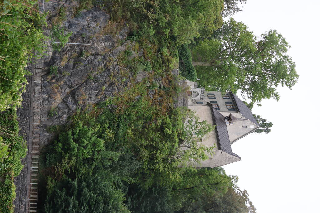A chapel and a house atop a rock.