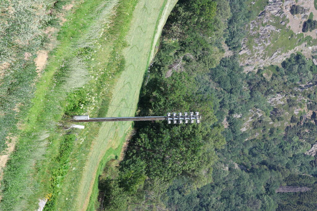 A lone telephone pole. It's not falling. The slope is steep.